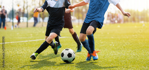 两个足球运动员边跑边踢足球。两个年轻足球运动员在比赛中的腿。