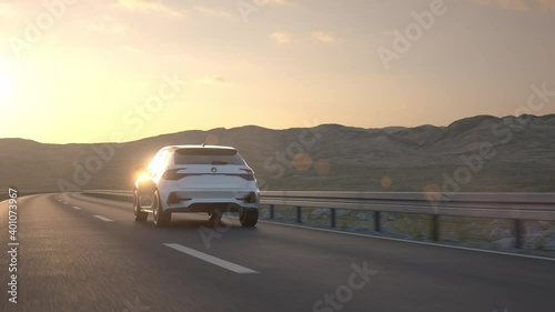 鸟瞰图，一辆自动驾驶的电动汽车沿着沙漠公路行驶到日落时分